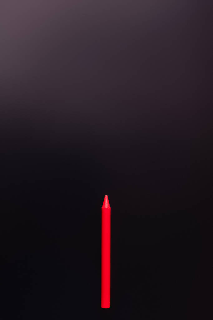 vista superior de crayón rojo sobre fondo negro - Foto, Imagen