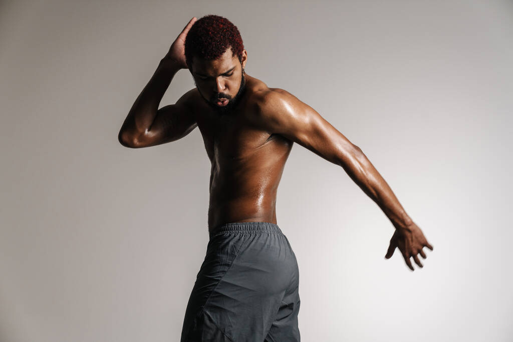 Černošky bez trička sportovec dělá cvičení při cvičení izolované přes bílé pozadí - Fotografie, Obrázek