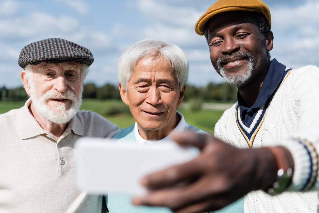 cheerful african american man taking selfie with senior multiethnic friends   - Photo, Image