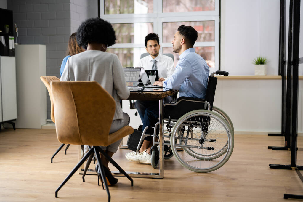 Engelli İş Adamı Konferans Odasında Dizüstü bilgisayarla Masada Oturuyor - Fotoğraf, Görsel
