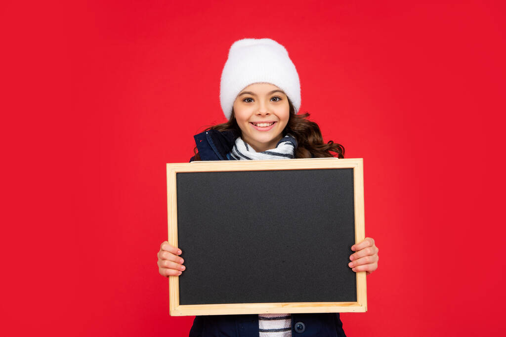 Kış satışları. Şapkalı olumlu bir çocuk. Kopya alanı olan karatahta tutan genç kız. - Fotoğraf, Görsel