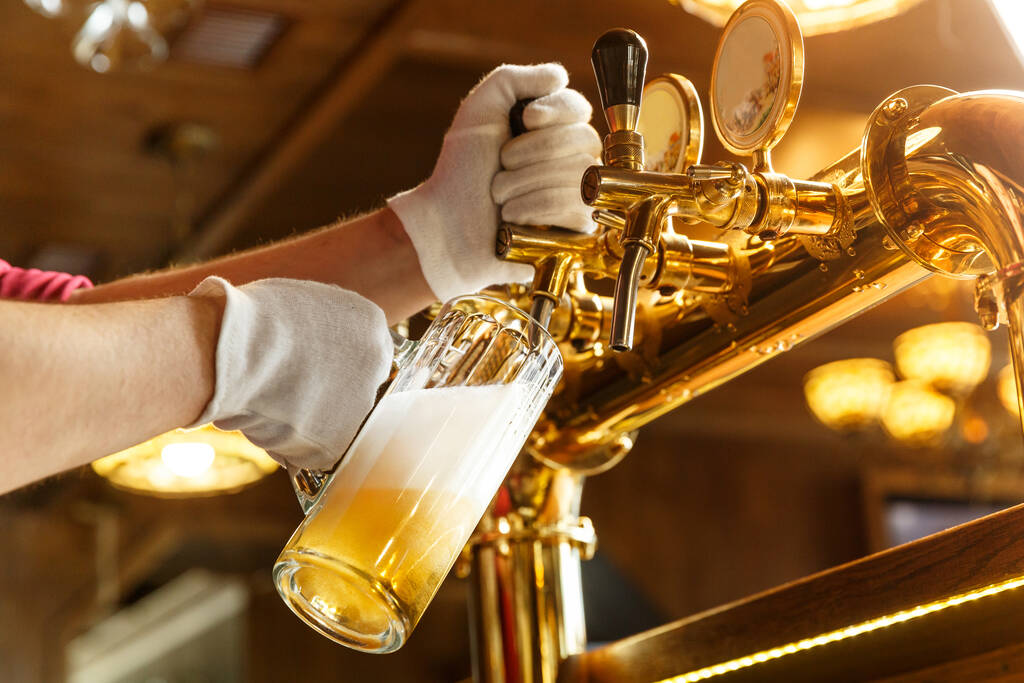 Camarero manos vertiendo cerveza ligera en un vaso de cerveza
 - Foto, Imagen