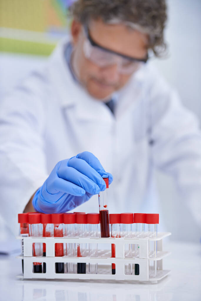 La ciencia ayuda a resolver crímenes. Una foto recortada de un científico maduro trabajando con muestras de sangre en su laboratorio. - Foto, Imagen