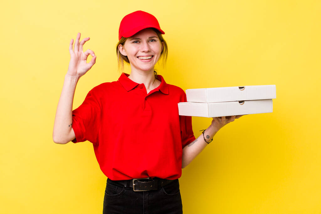 rote Kopf hübsche Frau glücklich, zeigt Zustimmung mit okay Geste. Pizza-Lieferkonzept - Foto, Bild