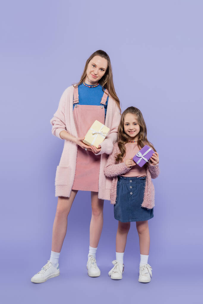 plná délka šťastný dítě a matka drží dárky na fialové - Fotografie, Obrázek