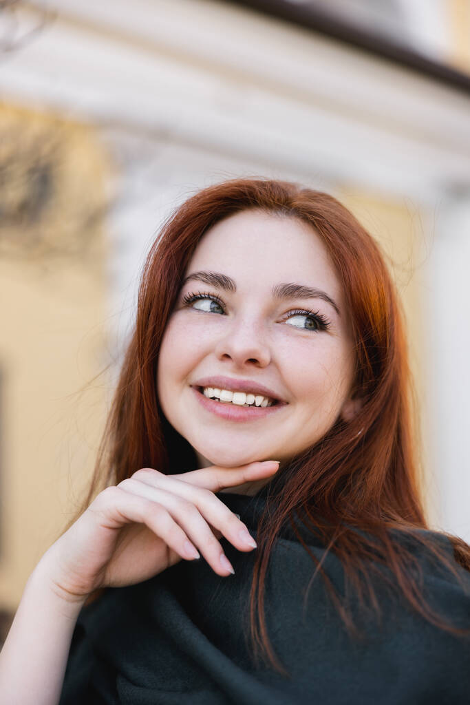 Porträt einer jungen positiven Frau mit Kopftuch, die wegschaut und lächelt - Foto, Bild