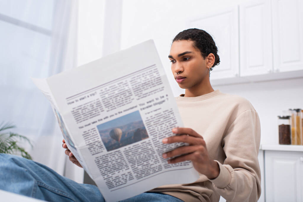 young african american man in sweatshirt reading newspaper in morning  - Foto, Imagem
