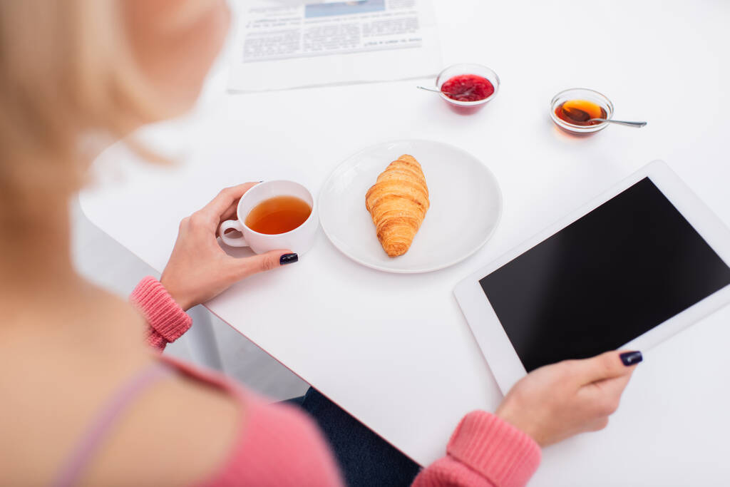 vista ad alto angolo della donna che utilizza tablet digitale durante la colazione  - Foto, immagini