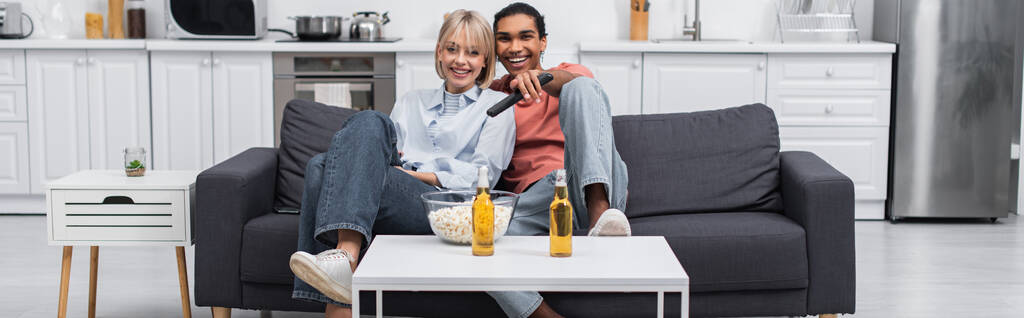 happy interracial couple watching movie together, banner  - Foto, Bild