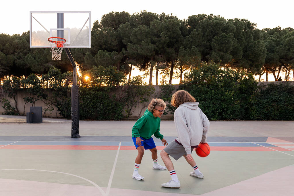 dwóch młodych przyjaciół gra w koszykówkę na dworze miejskim, koncepcja sportów miejskich na ulicy, kopiowanie miejsca na tekst - Zdjęcie, obraz