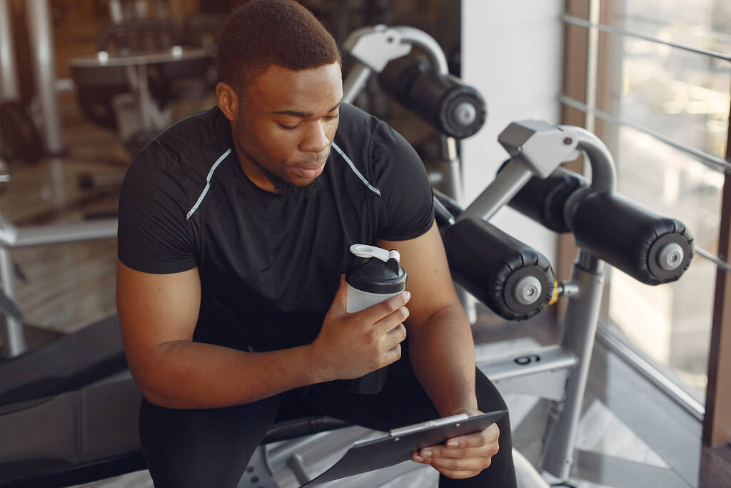 Ein schöner schwarzer Mann ist in einem Fitnessstudio beschäftigt - Foto, Bild