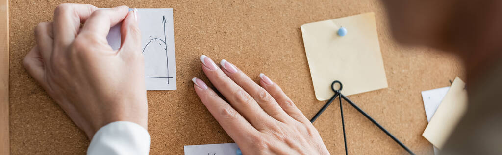 partial view of blurred banker pinning paper notes on corkboard, banner - Фото, изображение
