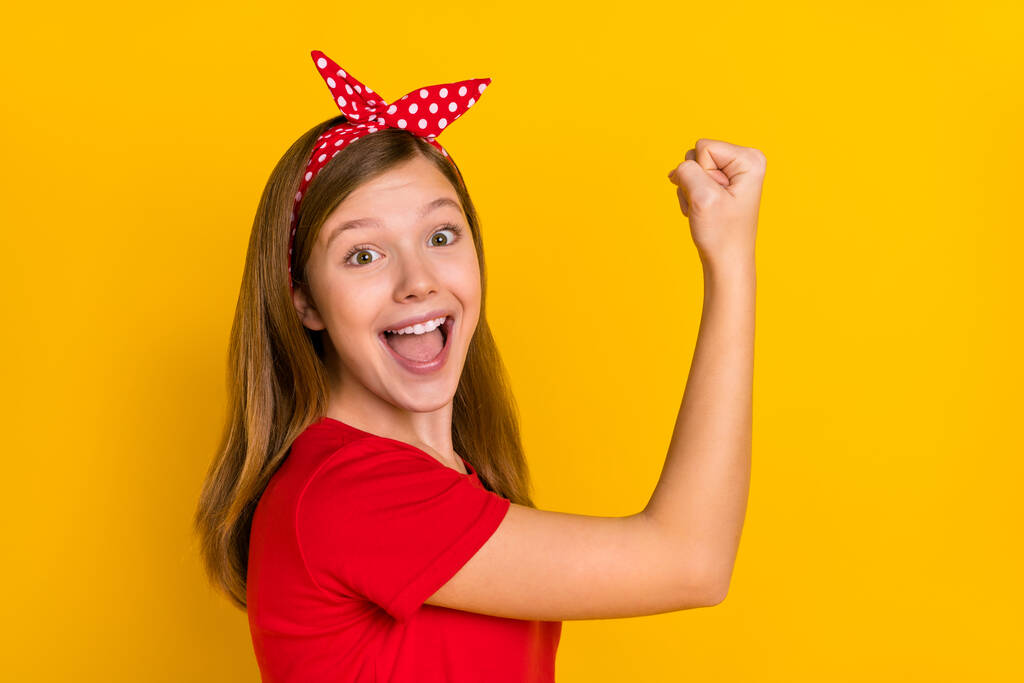 Фотографія профілю милої чарівної маленької дівчинки, яка піднімає кулаки в досягненнях перемоги жінка влада ізольована на жовтому кольорі
 - Фото, зображення