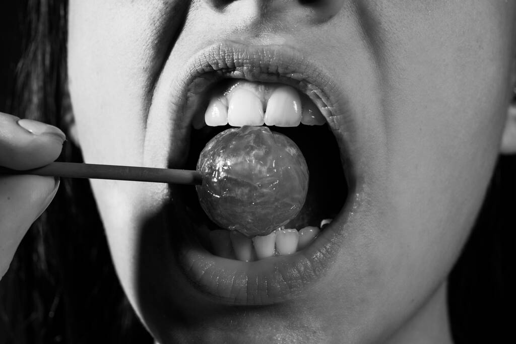 Glamor mouth licking yummy lollypop with red lips. Sucks lolli pop. Sexy female lip. Sensual woman red lips with a Lollipop. Candy bar concept. - Photo, Image