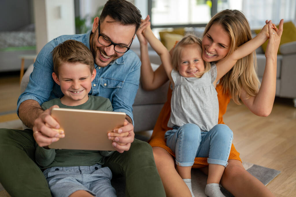 Dijital cihaz teknolojisi aile çevrimiçi eğitim kavramı. Evde dijital cihazları olan mutlu genç bir aile.. - Fotoğraf, Görsel