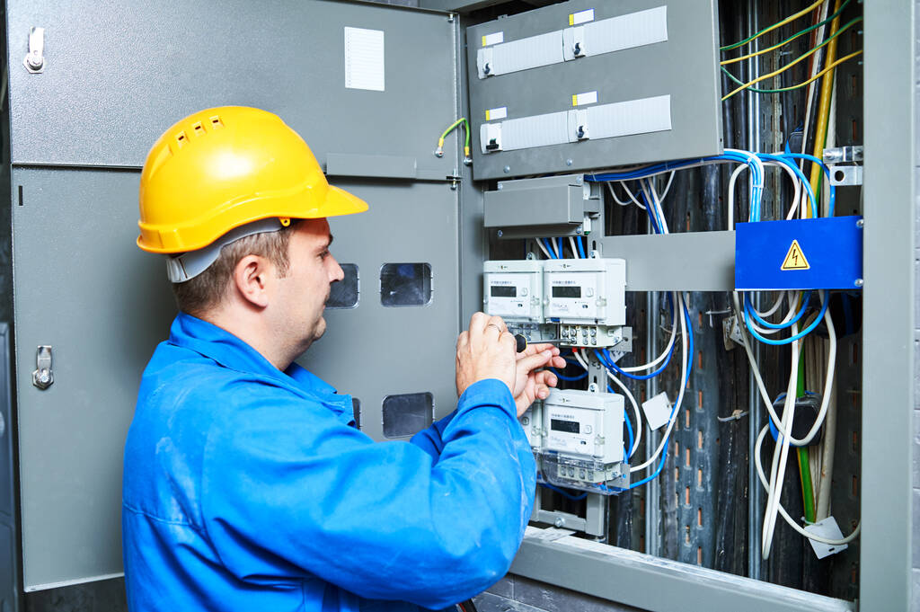 Electricista instalando contador de energía en panel de caja de interruptores - Foto, imagen