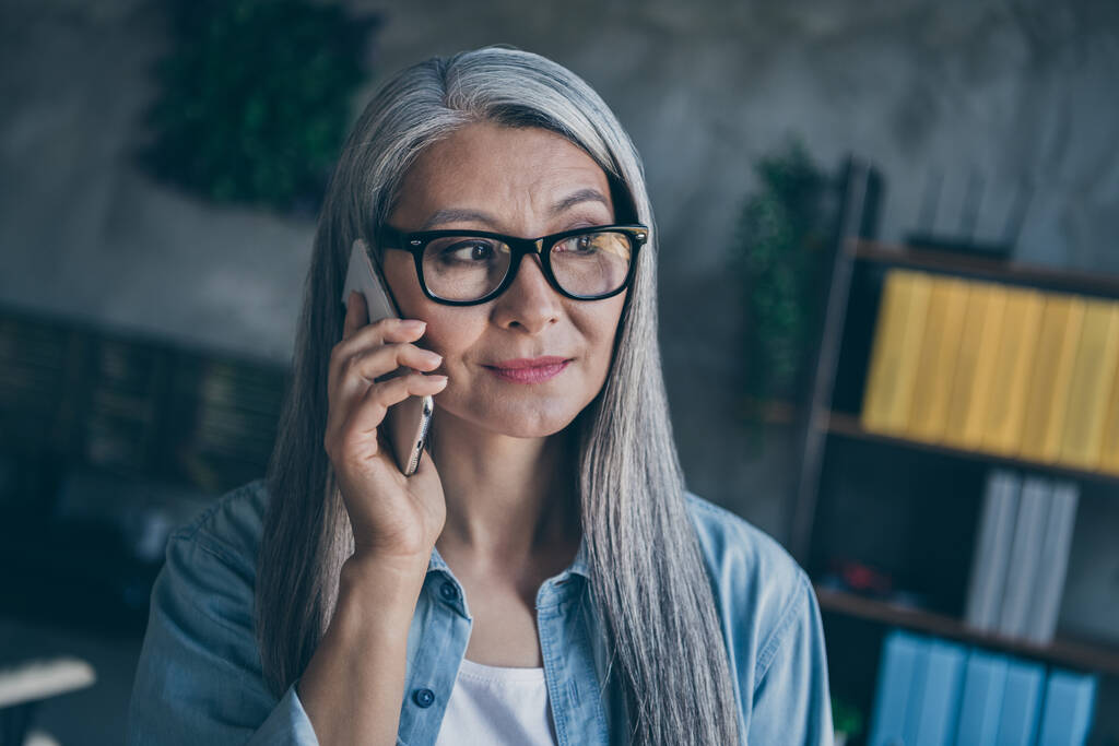 Porträt einer ruhigen, konzentrierten Geschäftsfrau, die im Büro telefoniert - Foto, Bild