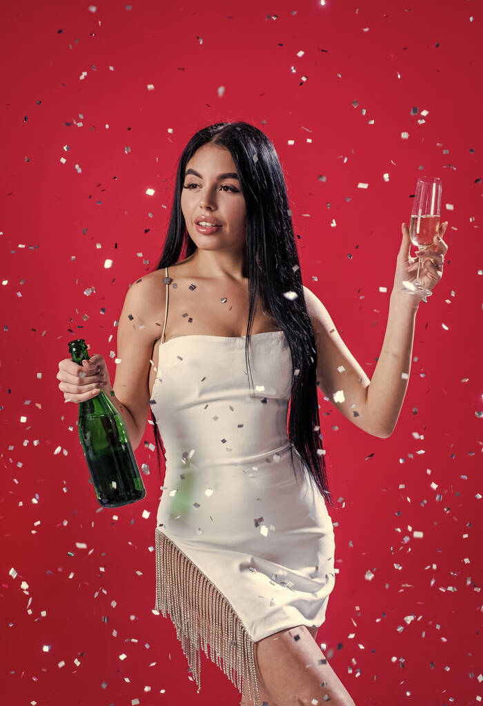сексуальная женщина пьет шампанское из бокала под падающими конфетти, годовщина - Фото, изображение