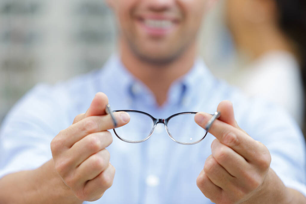 z bliska widok okularów posiadanych przez męskiego optyka - Zdjęcie, obraz