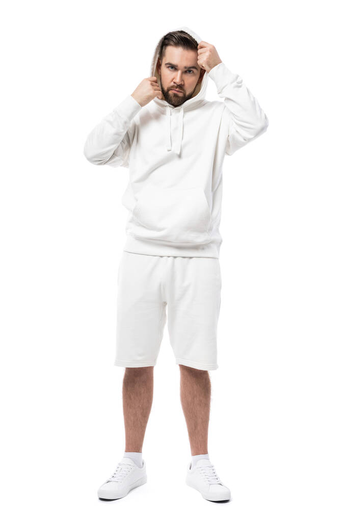 Hombre guapo con capucha blanca en blanco y pantalones cortos aislados sobre fondo blanco - Foto, imagen