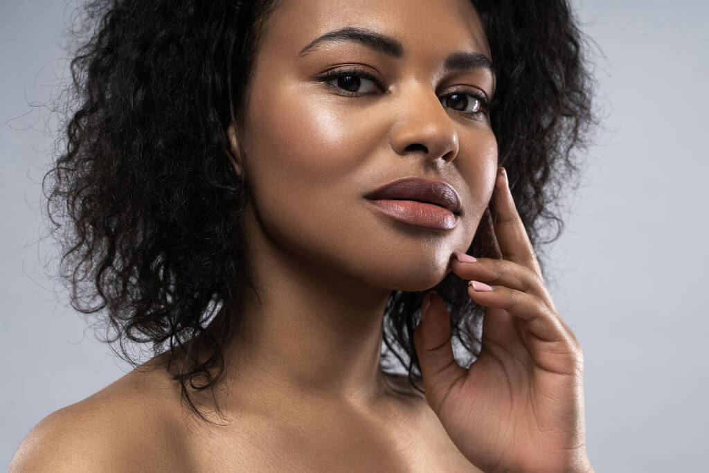 Портрет красивой черной женщины с гладкой кожей на сером фоне - Фото, изображение