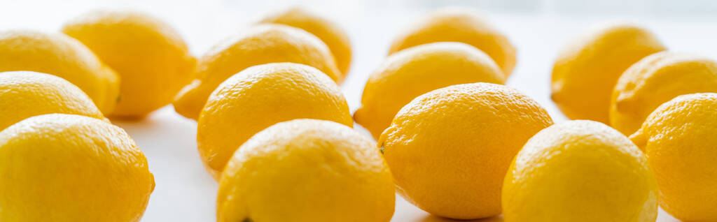 Lemons with light on white background, banner  - Foto, afbeelding