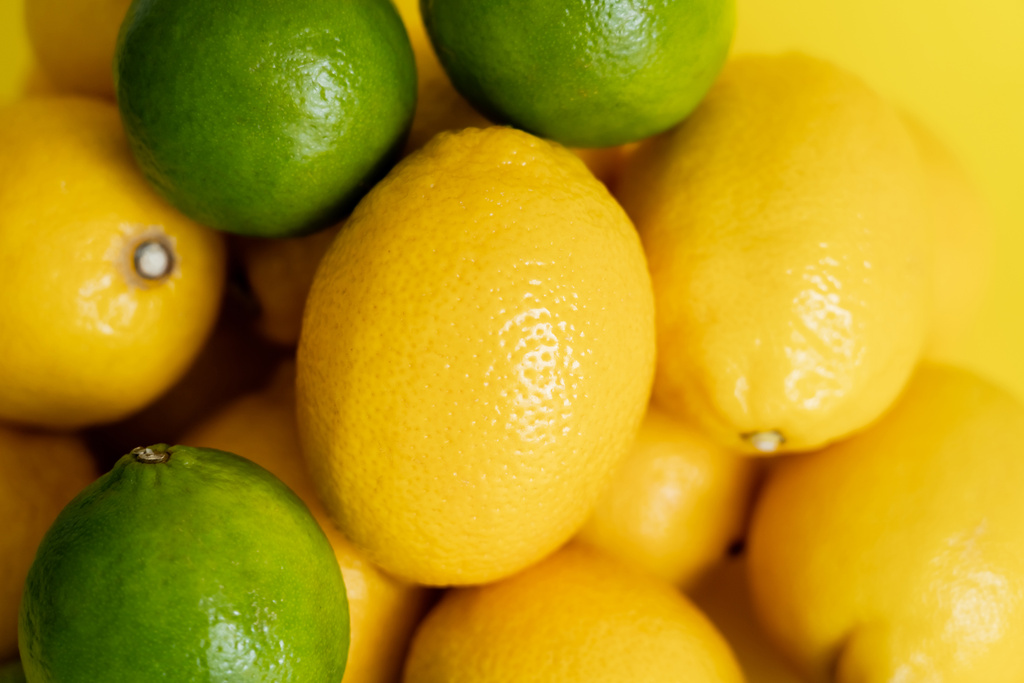 Sarı yüzeyde olgun limon ve limonların yakın görüntüsü  - Fotoğraf, Görsel
