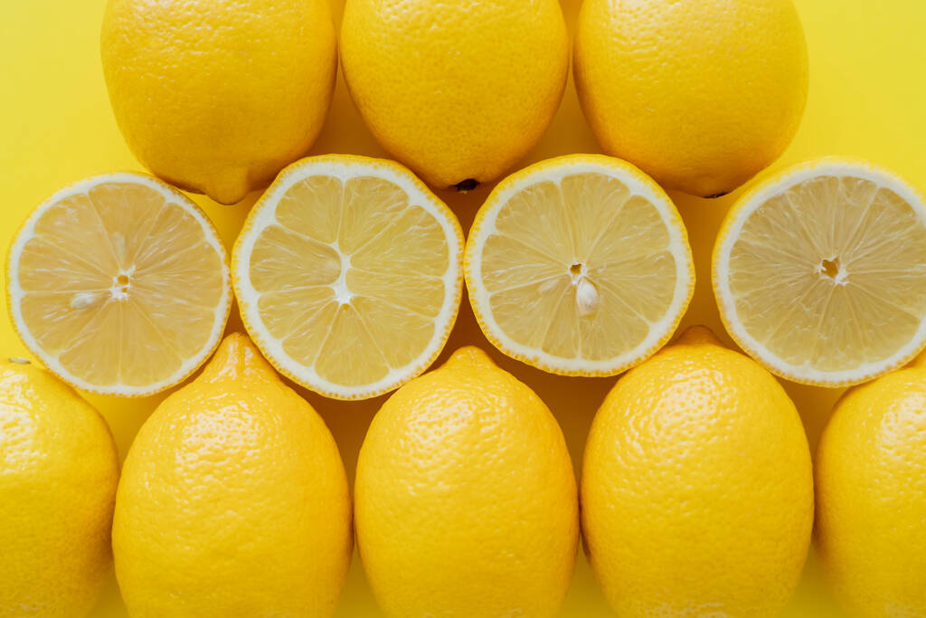 Flat lay with bright lemons on yellow surface  - Fotó, kép