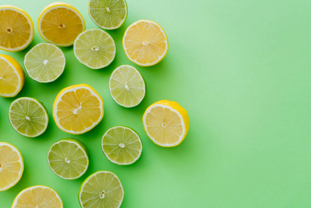 Top view of cut citrus on green background - Фото, изображение