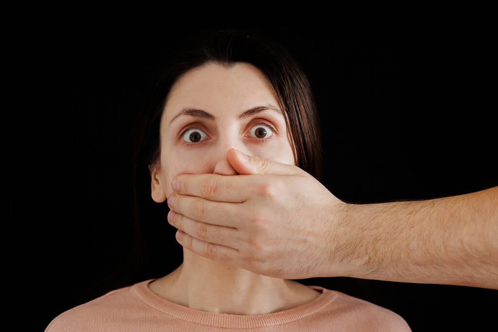 Το αντρικό χέρι κλείνει το στόμα της γυναίκας, καταπάτηση των δικαιωμάτων των γυναικών - Φωτογραφία, εικόνα