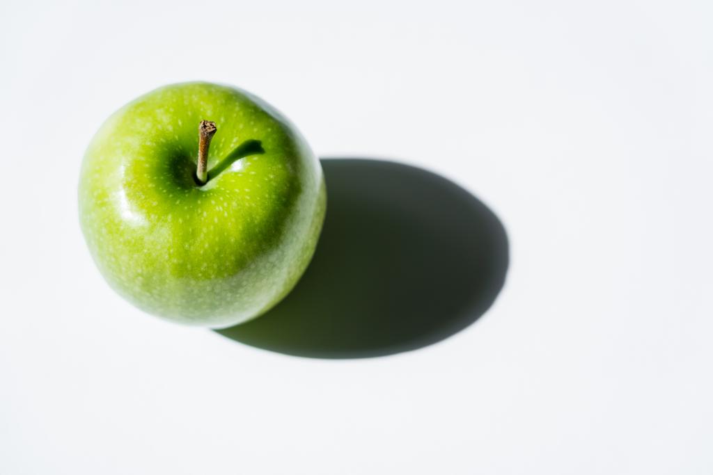 top view of shadow near green apple on white - 写真・画像