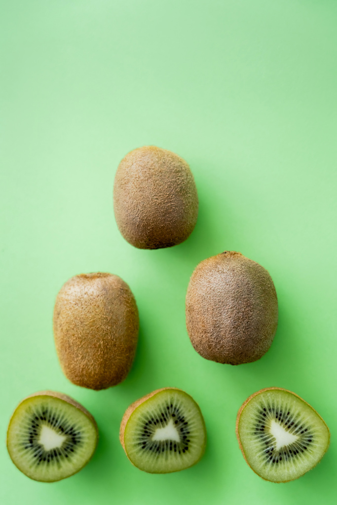 top view of organic kiwi fruit on green - Foto, afbeelding
