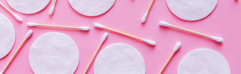 top view of cosmetic cotton pads and hygienic ear sticks on pink background, banner - Photo, Image