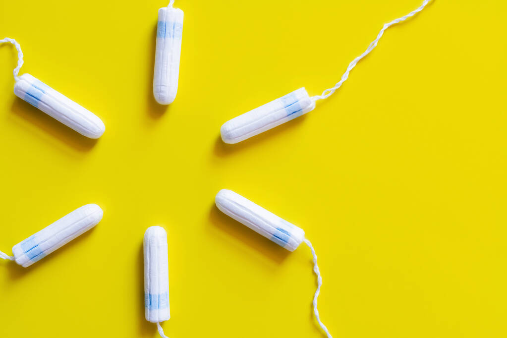 Kreis hygienischer Tampons auf leuchtend gelbem Hintergrund, Draufsicht - Foto, Bild