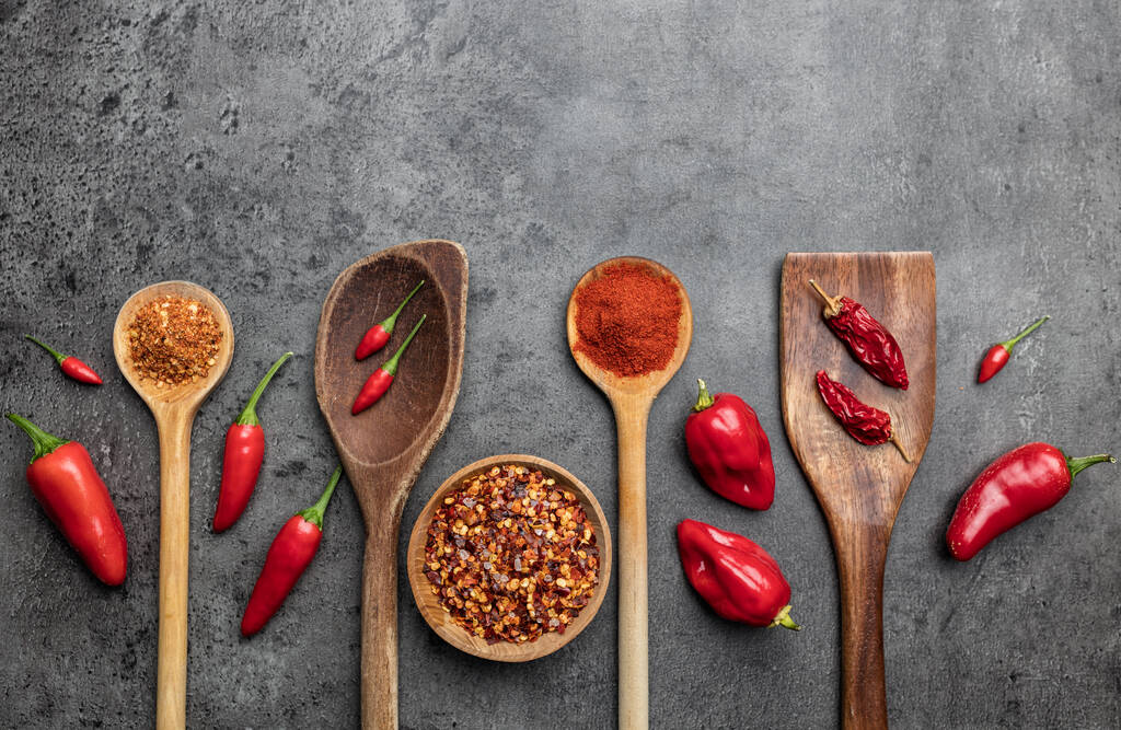 Variety čerstvých a sušených chilli papriček na rustikálním pozadí - Fotografie, Obrázek