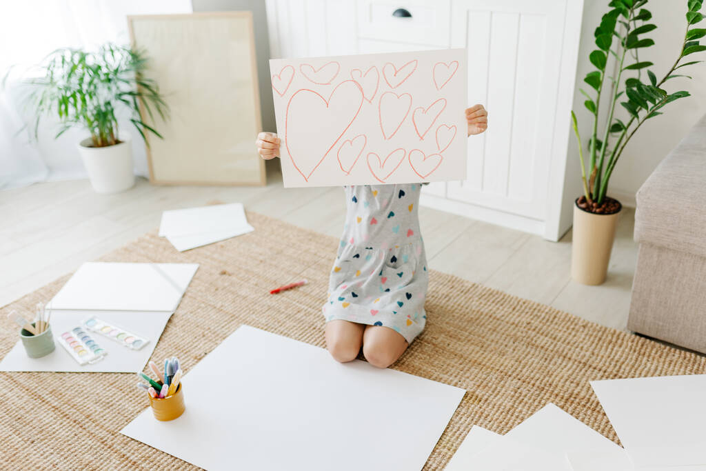 Bambino spettacolo disegnare con un sacco di cuori - Foto, immagini