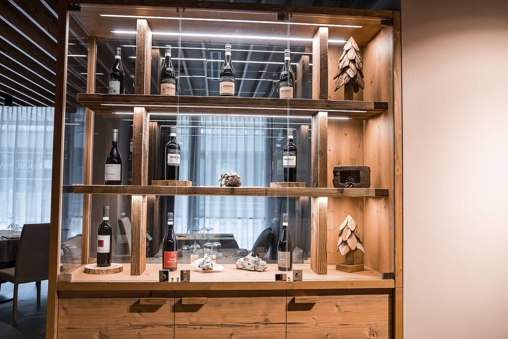 St. Anton am Arlberg. March 10, 2022. Rows of delicious wine bottles on shelves in modern hotel, Racks with wine bottles on shelves in hotel lobby - Photo, Image