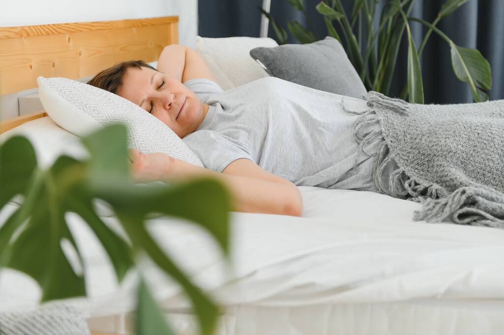 mujer de mediana edad durmiendo en la cama en casa - Foto, imagen