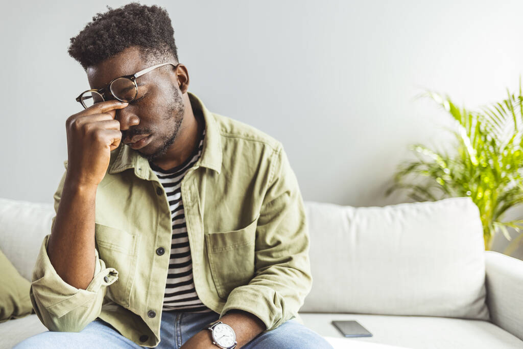 Rozčílený mladý Afričan americký muž, který se s pocitem silné bolesti hlavy vypořádal s myšlenkou, vyčerpaným černým chlapem, který se cítil frustrovaný, unavený dotek na čele trpí migraine - Fotografie, Obrázek