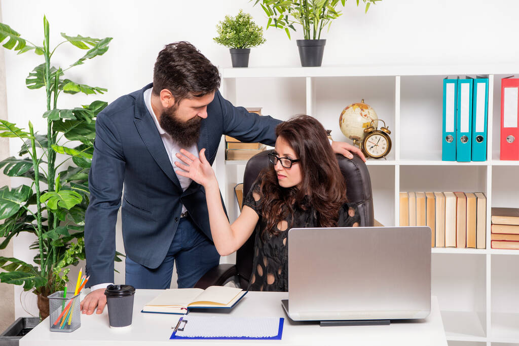 Серьезный бизнесмен и деловая женщина обсуждают рабочие задачи в офисе, работают - Фото, изображение