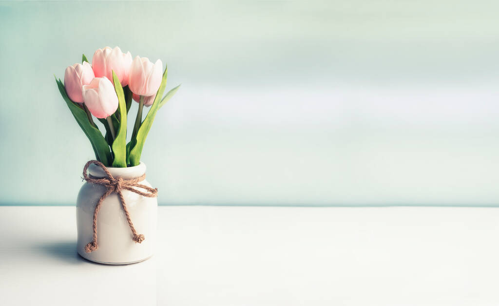 Аромат искусственных цветов нежных тюльпанов в вазе на светлом фоне. баннер. Много места для ваших текстов и надписей. - Фото, изображение