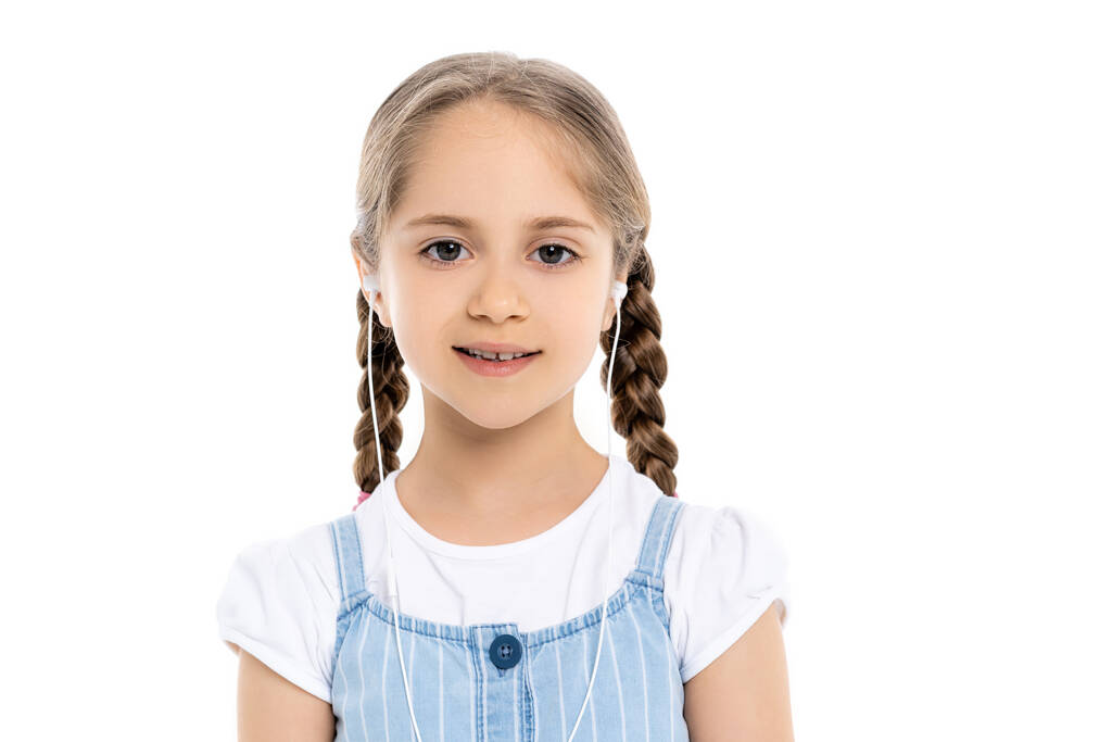 χαρούμενο κορίτσι με ενσύρματα ακουστικά χαμογελώντας στην κάμερα απομονωμένη στα λευκά - Φωτογραφία, εικόνα