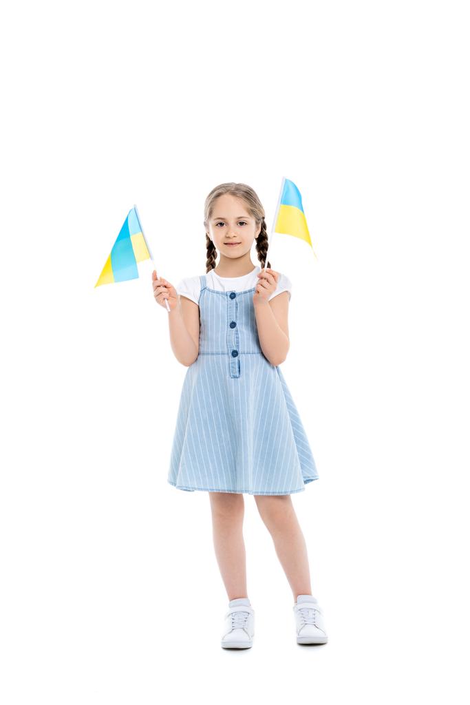 повний вигляд дівчини в блакитній сукні з маленькими українськими прапорами на білому
 - Фото, зображення