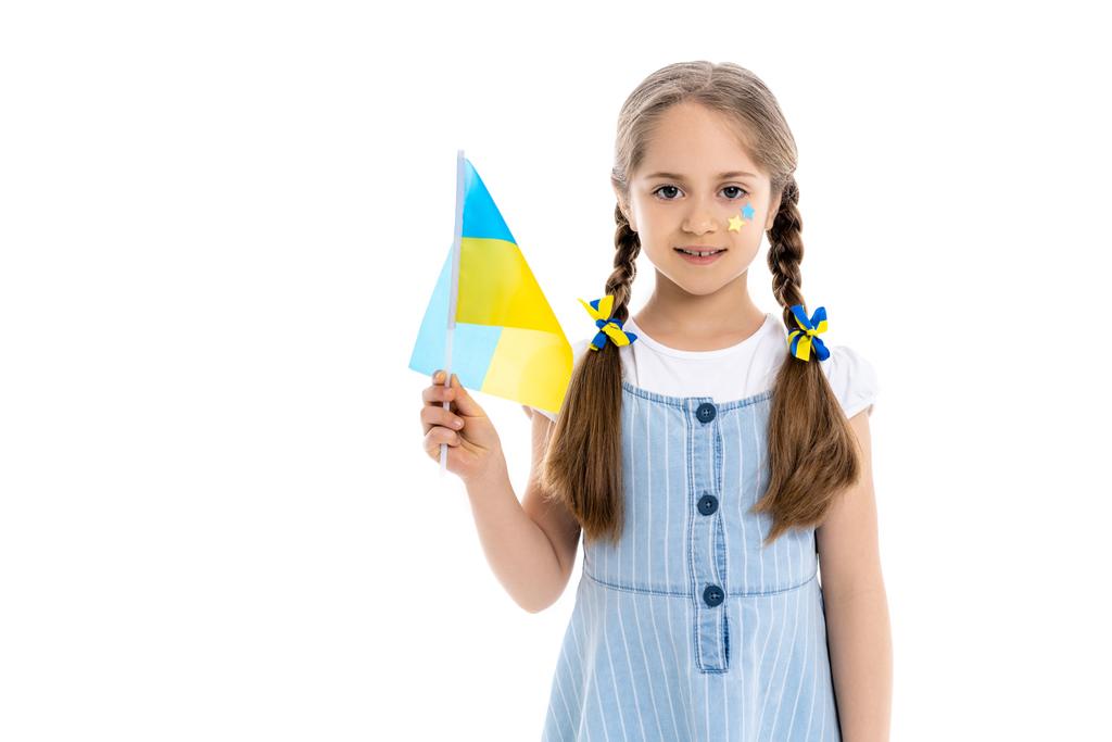 Patriotisches Mädchen mit blauen und gelben Sternen und Bändern mit ukrainischer Flagge auf weißem Grund - Foto, Bild