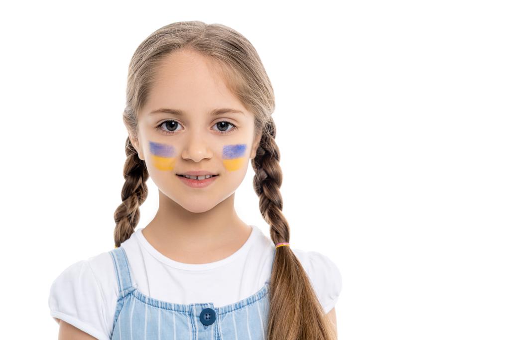 Porträt eines lächelnden Mädchens mit ukrainischen Nationalflaggen auf dem Gesicht isoliert auf weiß - Foto, Bild