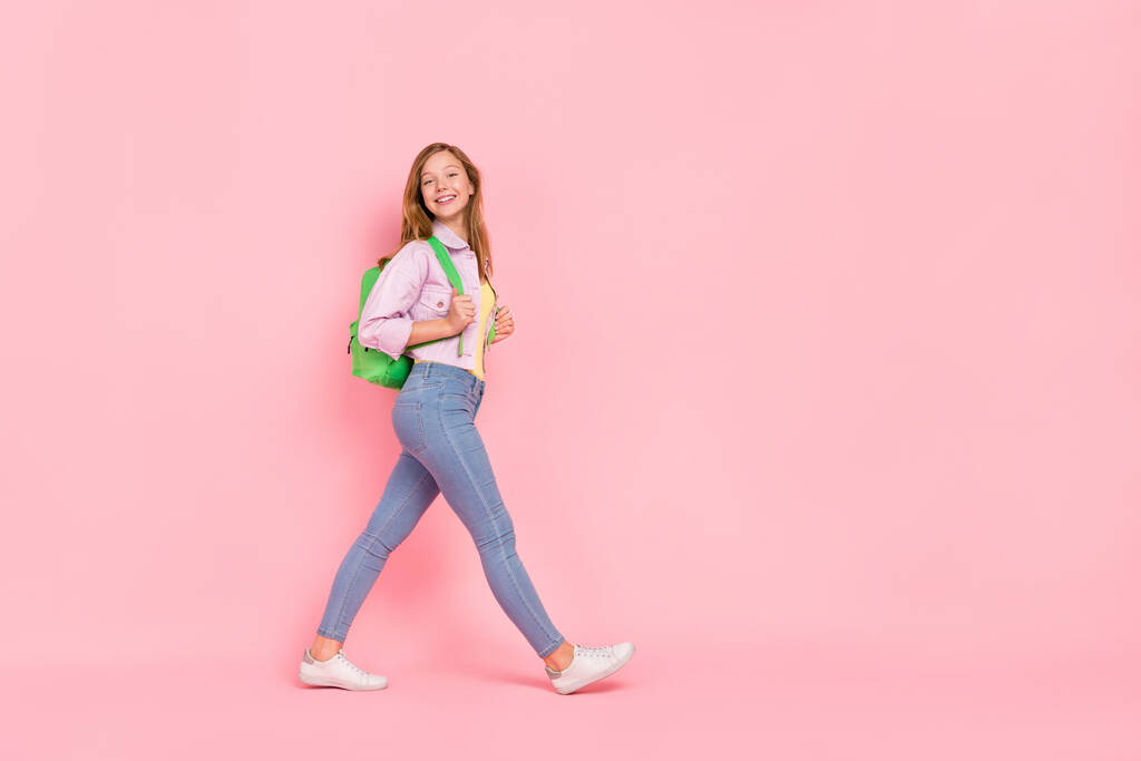 Foto lateral de perfil de longitud completa de la joven atractiva chica caminar espacio vacío desgaste traje casual aislado sobre fondo de color rosa - Foto, Imagen