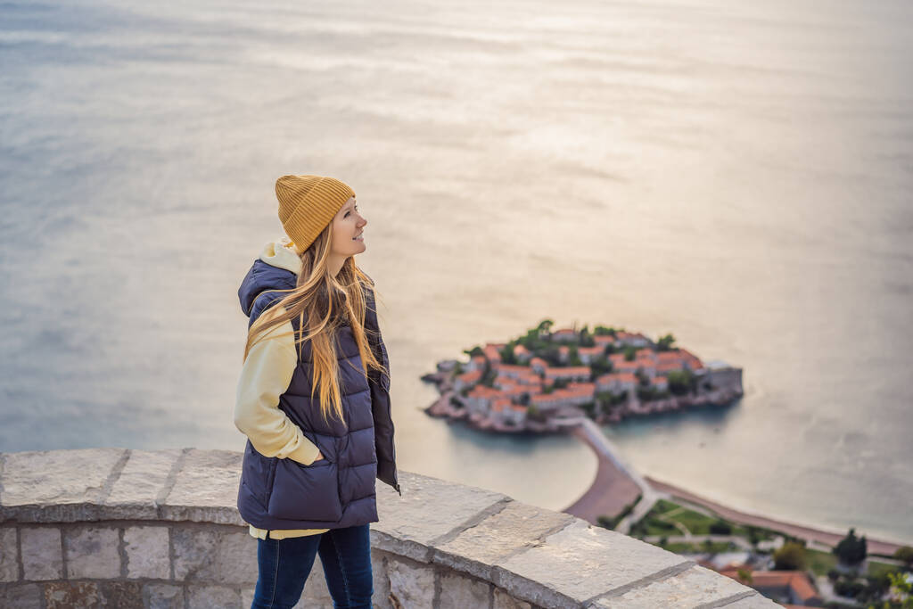 Donna turista sullo sfondo della splendida vista dell'isola di Santo Stefano, Sveti Stefan sulla riviera di Budva, Budva, Montenegro. Viaggio in Montenegro concetto - Foto, immagini