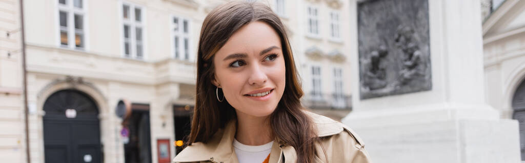 giovane donna sorridente in trench sulla strada europea, striscione - Foto, immagini