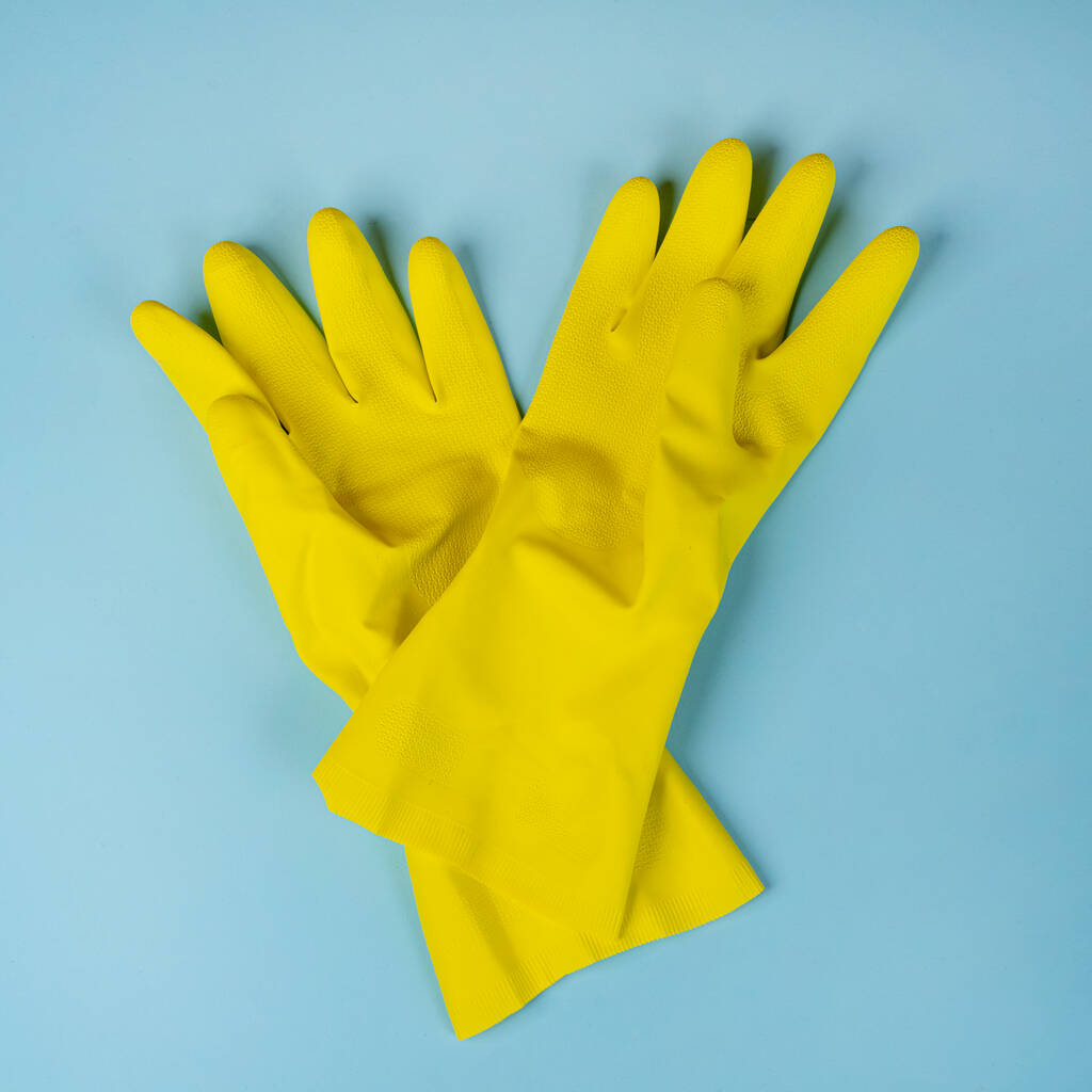 two yellow rubber cleaning gloves.  on a blue surface - Photo, Image