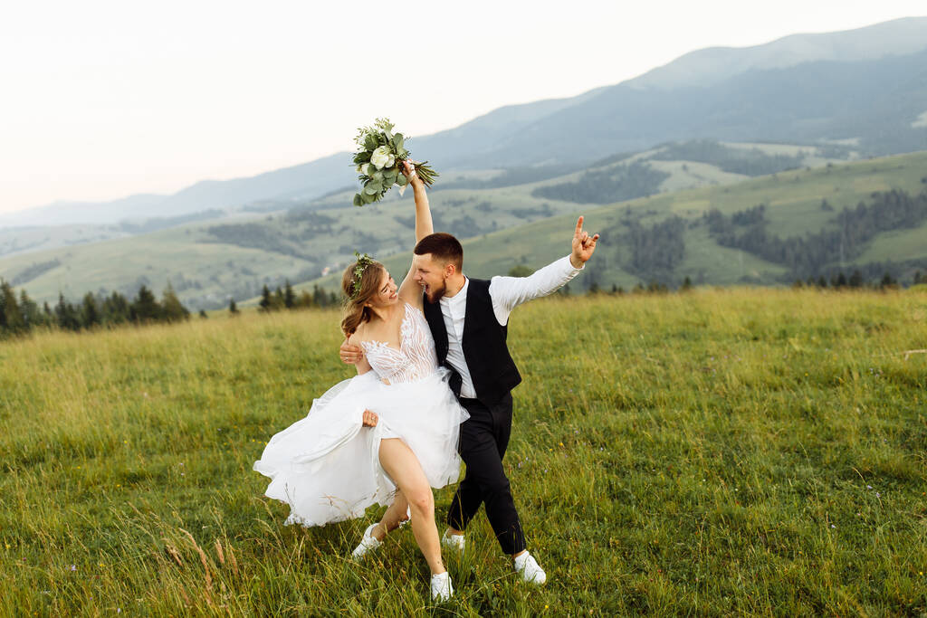 mooi jong bruiloft paar in liefde poseren op de achtergrond van de bergen - Foto, afbeelding